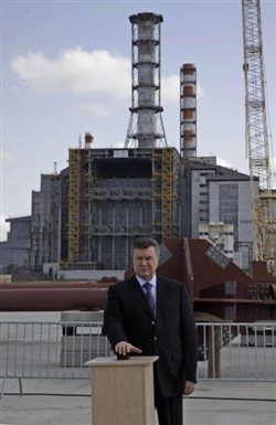 Ο πρόεδρος Βίκτορ Γιανούκοβιτς στην τελετή θεμελίωσης. Πίσω του, η παλιά σαρκοφάγος έχει επικίνδυνες ρωγμές. (Φωτογραφία: Associated Press)