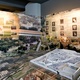 Η σύγχρονη πόλη συναντά την αρχαία - από τη σημερινή Πλάκα στη μακέτα της τότε Αθήνας, υπό το βλέμμα των Ελλήνων και Αμερικανών αρχαιολόγων που μας την αποκάλυψαν με τις πολύχρονες ανασκαφές τους